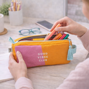 Astuccio maxi colorato “Good Vibes Club” su una scrivania ordinata, utilizzato come portapenne e accessori, con quaderni e cancelleria intorno in un contesto lifestyle moderno e creativo.