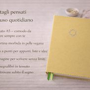 Taccuino elegante giallo con copertina in pelle vegana, presentato con testo overlay che evidenzia formato A5, carta a punti, 240 pagine e doppio segnalibro per l’uso quotidiano.

